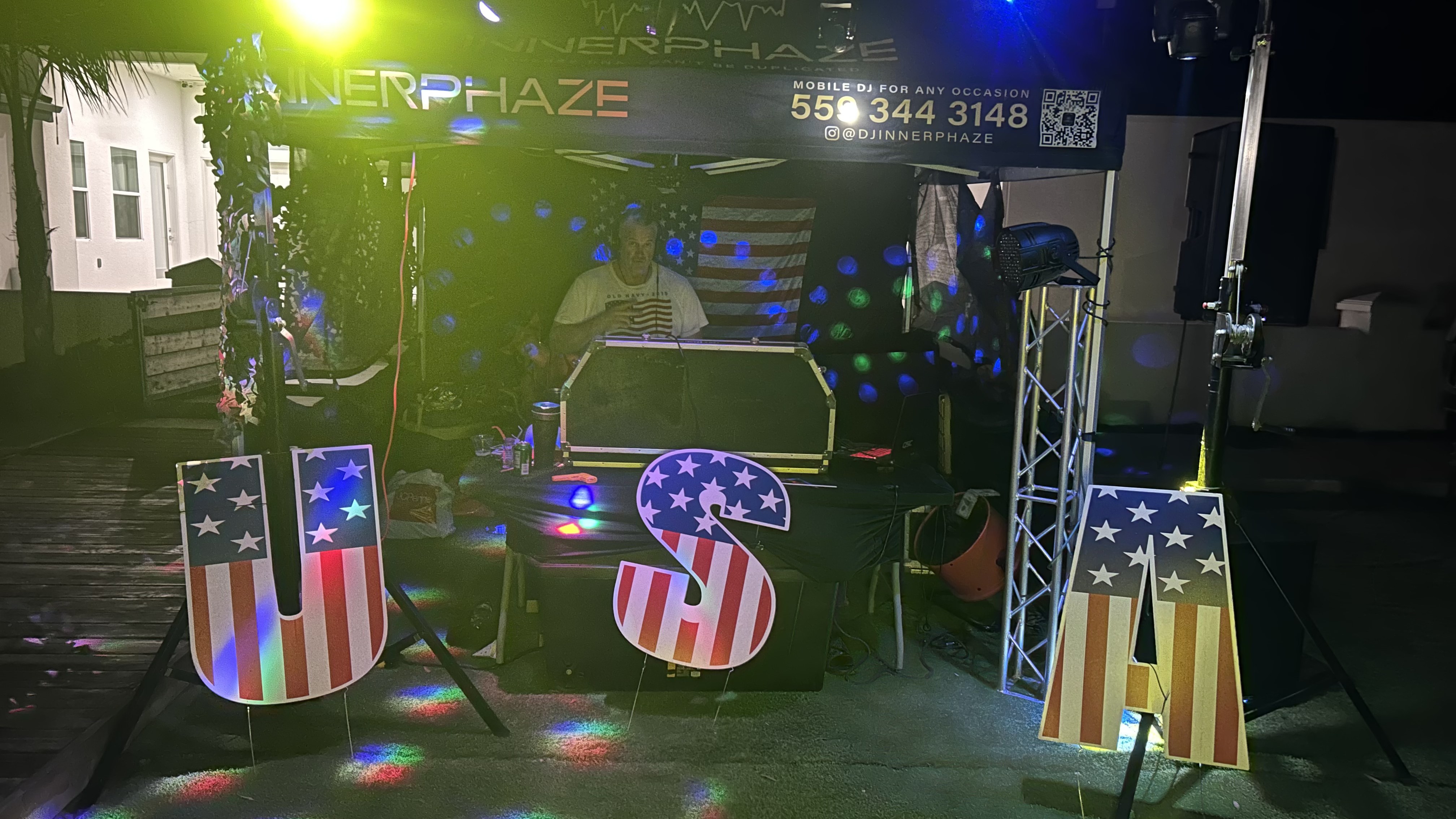 InnerPhaze DJ booth with USA marquee letters at a nighttime party